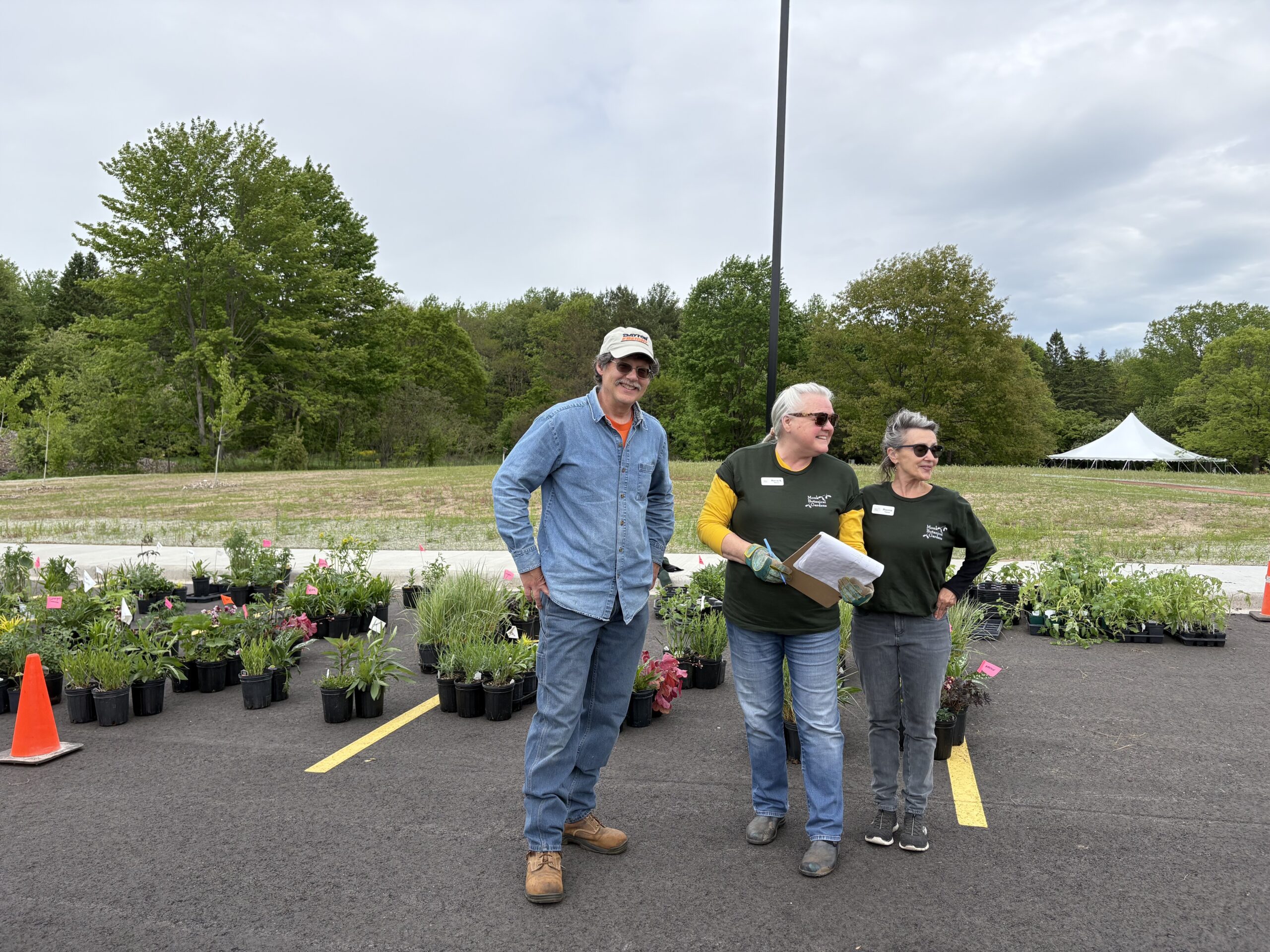 Volunteers standing by pots of plants at pickup